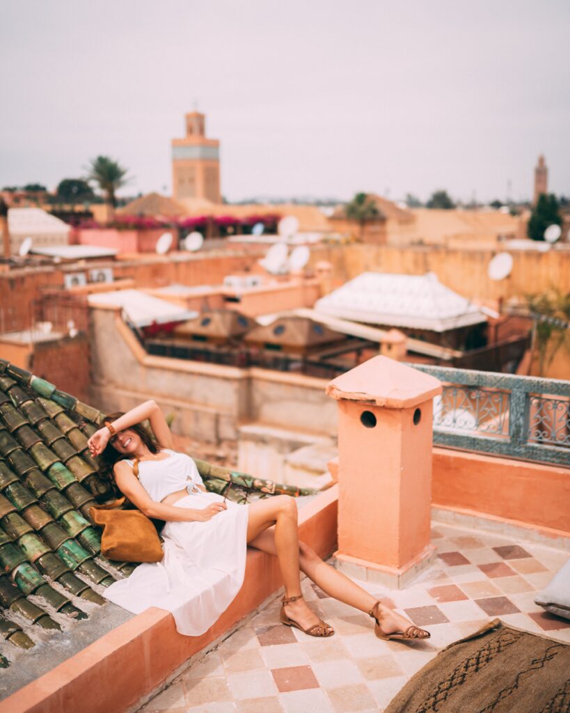 Woman dressed in white relaxing on the rooftop in Morocco