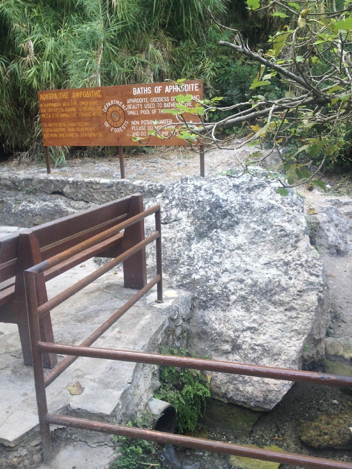 The Baths of Aphrodite grotto surrounded by greenery near Latchi