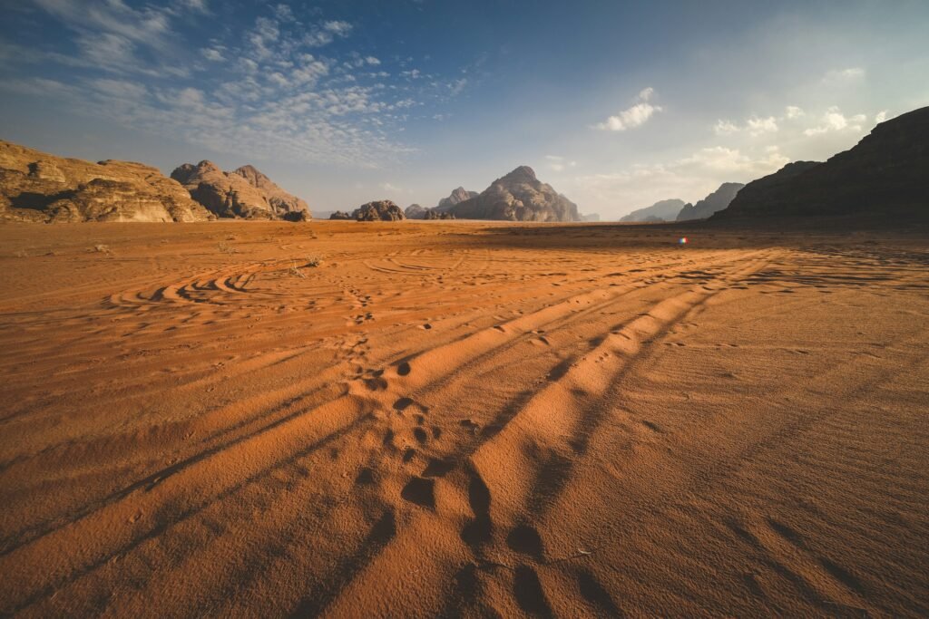 Long straight road through the Jordanian desert beneath a dramatic sky