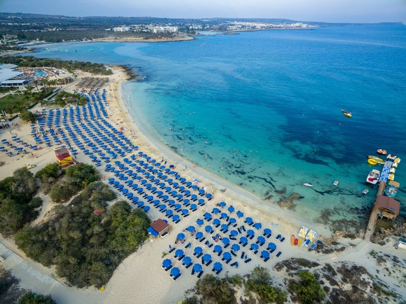 Aerial view of Makronissos Beach near Ayia Napa with sandy shore and blue water