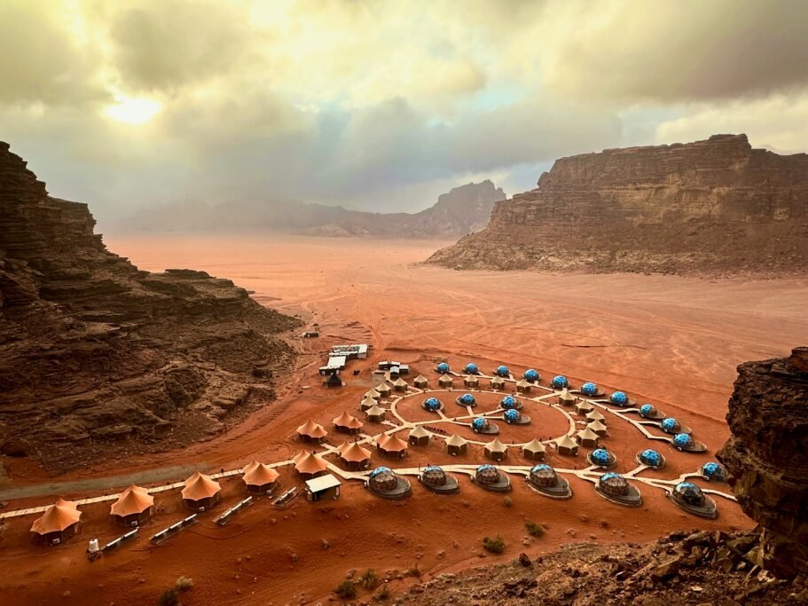 Rental car parked on a desert road in Jordan with rocky landscape in the background