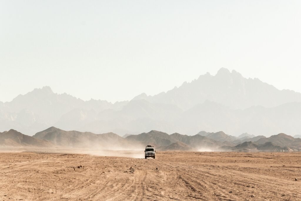Car driving along a scenic road in Jordan with mountains and desert views