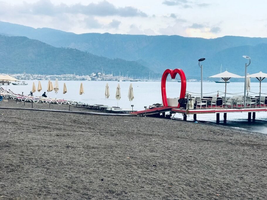 Marmaris Public Beach with sand, clear water, and coastal promenade