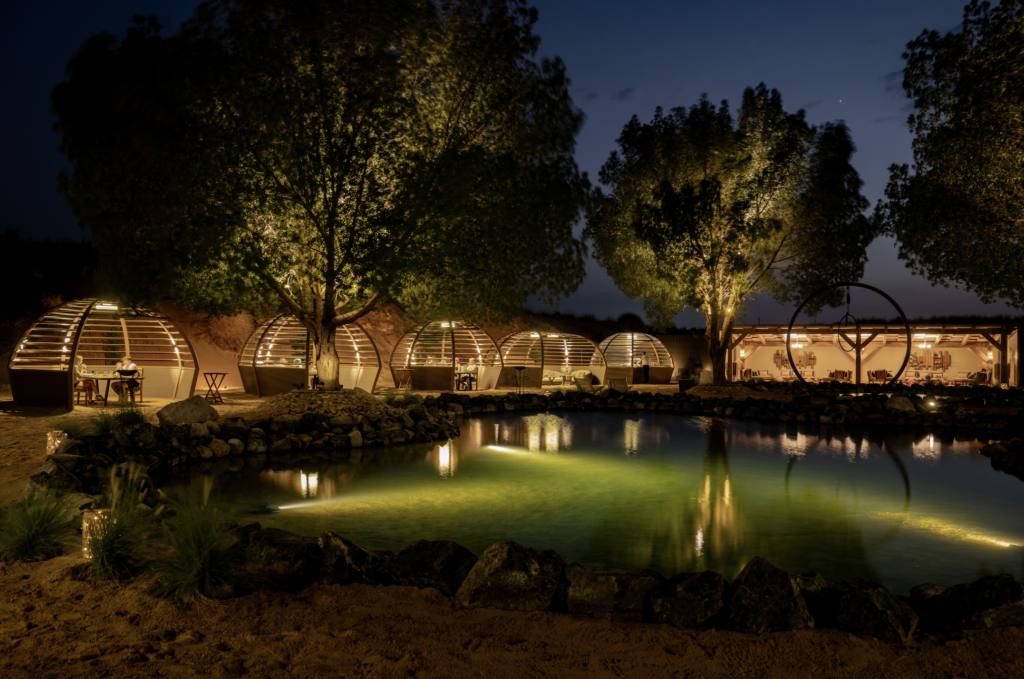 Romantic Dubai desert camp dinner with lanterns and traditional seating