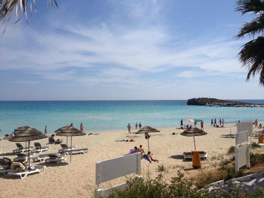 Nissi Beach in Ayia Napa with pale sand, turquoise water, and an offshore islet