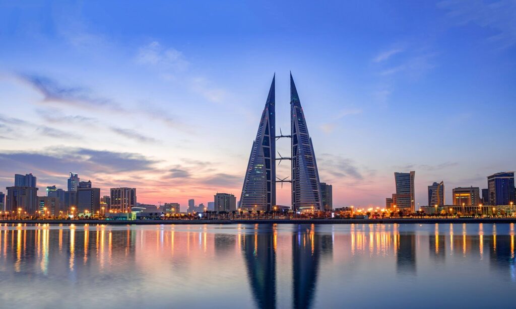 Bahrain World Trade Center and Manama skyline reflected in the water at sunset