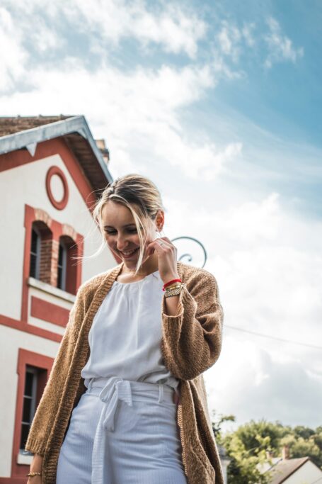 Woman wearing a lightweight cardigan over a white top outdoors